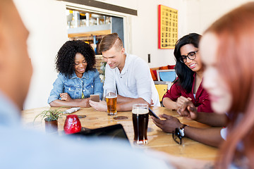 Image showing happy friends with smartphone drinking beer at bar