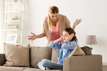 Image showing girl closing ears to not hear angry mother at home