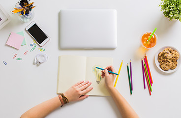 Image showing woman hands drawing in notebook at home office