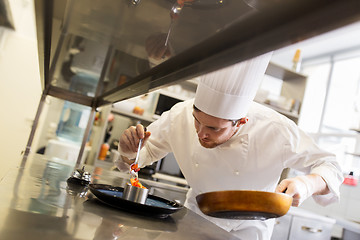 Image showing happy male chef cooking food at restaurant kitchen