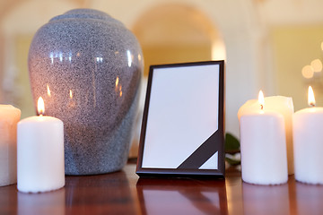 Image showing photo frame, cremation urn and candles in church