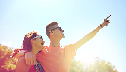 Image showing happy couple pointing finger at summer park