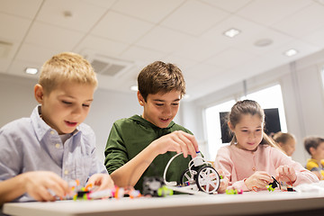 Image showing happy children building robots at robotics school