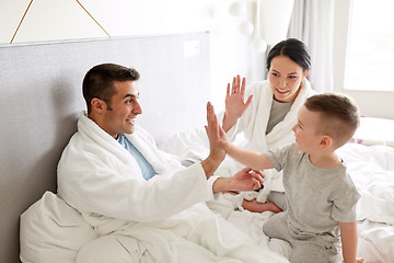 Image showing happy family in bed at home or hotel room