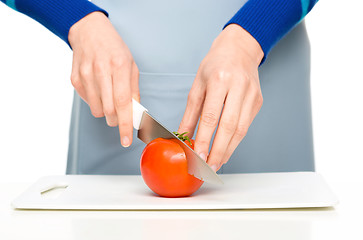 Image showing Cook is chopping red tomato