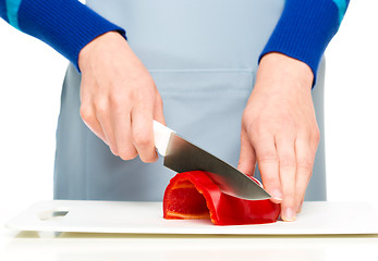 Image showing Cook is chopping bell pepper