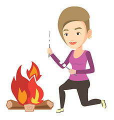 Image showing Woman roasting marshmallow over campfire.