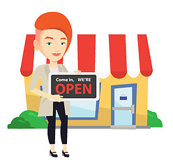 Image showing Female shop owner holding open signboard.