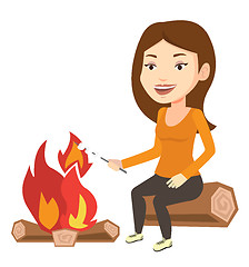 Image showing Woman roasting marshmallow over campfire.