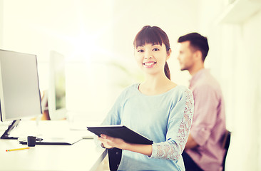 Image showing happy creative female office worker with tablet pc