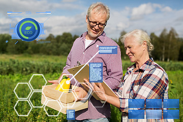 Image showing senior couple with box of vegetables at farm