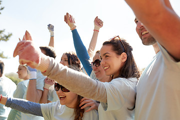 Image showing group of volunteers celebrating success in park