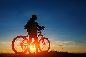 Image showing Silhouette of a bike on sky background