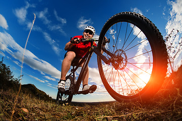 Image showing cyclist riding mountain bike on rocky trail at sunrise