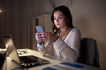 Image showing businesswoman with smartphone and laptop at office