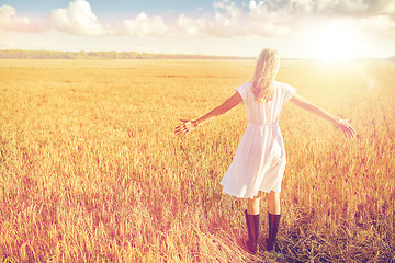 Image showing happy young woman in white dress on cereal field