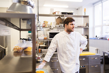 Image showing happy male chef cooking food at restaurant kitchen