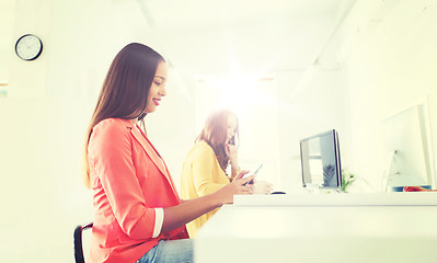 Image showing businesswoman texting on smartphone at office