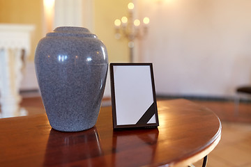 Image showing photo frame with mourning ribbon and cremation urn