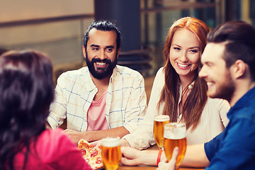 Image showing friends eating pizza with beer at restaurant