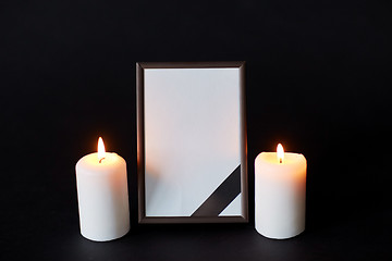 Image showing black ribbon on photo frame and candles at funeral