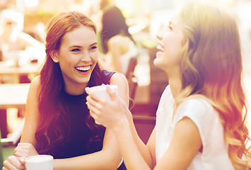 Image showing smiling young women with coffee cups at cafe