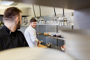 Image showing chef and cook cooking food at restaurant kitchen