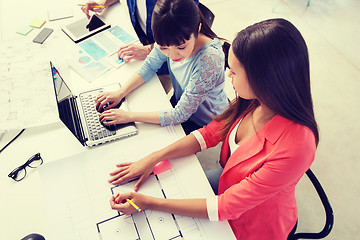 Image showing creative team with laptop and blueprint at office