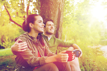 Image showing happy couple with cups drinking in nature