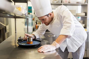 Image showing happy male chef cooking food at restaurant kitchen