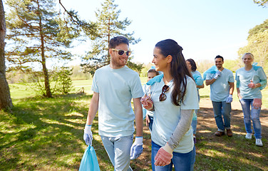 Image showing volunteers with garbage bags talking outdoors