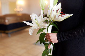 Image showing close up of woman with lily flowers at funeral