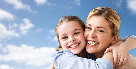 Image showing happy family of girl and mother hugging over sky