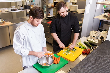 Image showing happy male chef cooking food at restaurant kitchen