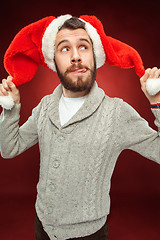 Image showing Surprised christmas man wearing a santa hat