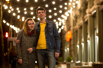 Image showing Outdoor portrait of young beautiful happy smiling couple posing on street.