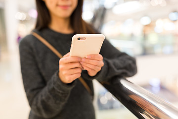 Image showing Woman working on cellphone in shopping mall