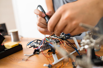 Image showing Welding the wire on drone at home