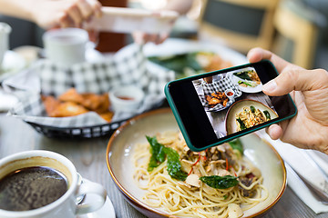 Image showing Friends taking photo on cellphone in restaurant