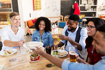 Image showing happy friends eating at restaurant