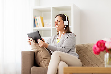 Image showing happy woman with tablet pc and headphones at home