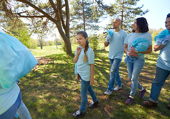 Image showing volunteers with garbage bags walking outdoors