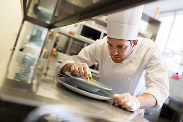 Image showing happy male chef cooking food at restaurant kitchen