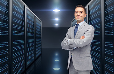 Image showing smiling businessman over server room background