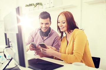 Image showing happy creative team with smartphones at office