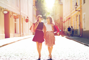 Image showing happy women with shopping bags walking in city