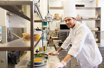 Image showing happy male chef cooking food at restaurant kitchen