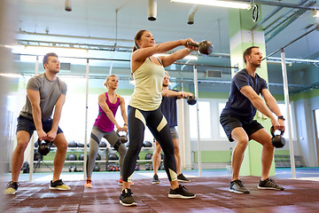 Image showing group of people with kettlebells exercising in gym