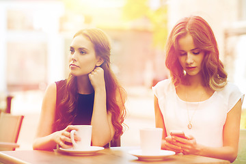 Image showing women with smartphones and coffee at outdoor cafe