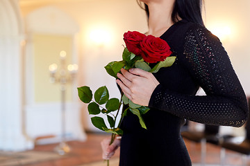 Image showing woman with red roses at funeral in church